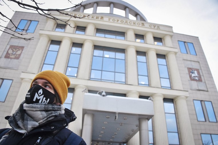 A demonstrator wearing a mask with the logo of Russia's rights group Memorial stands outside the Moscow City Court in 2021. 