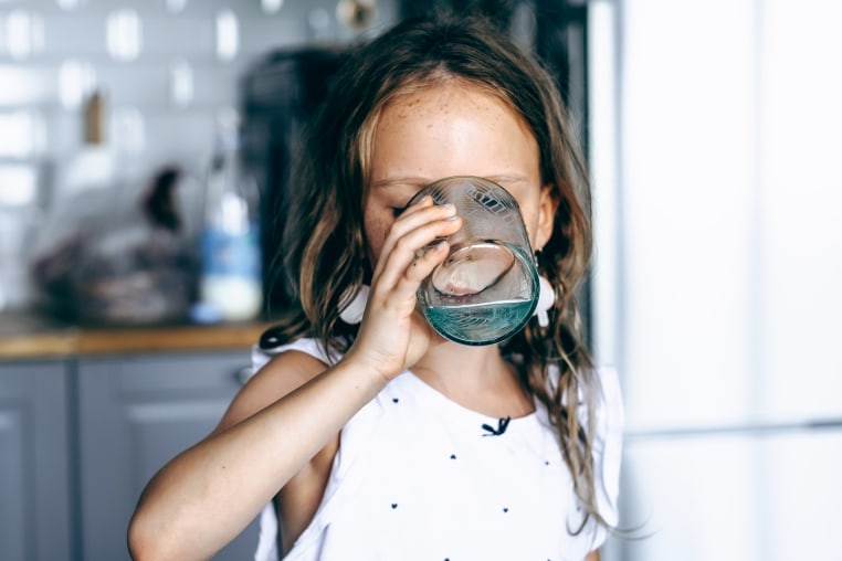 Image: A young girl drinking a glass of water