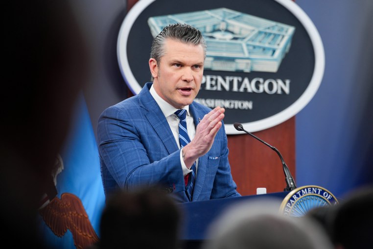 Pete Hegseth speaks while standing at a podium