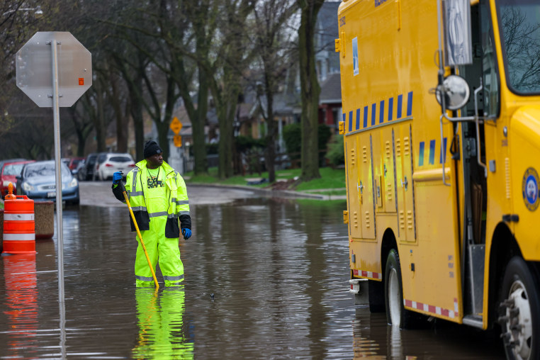 A worker with the Milwaukee Department of Public Works unclogs a storm drain.
