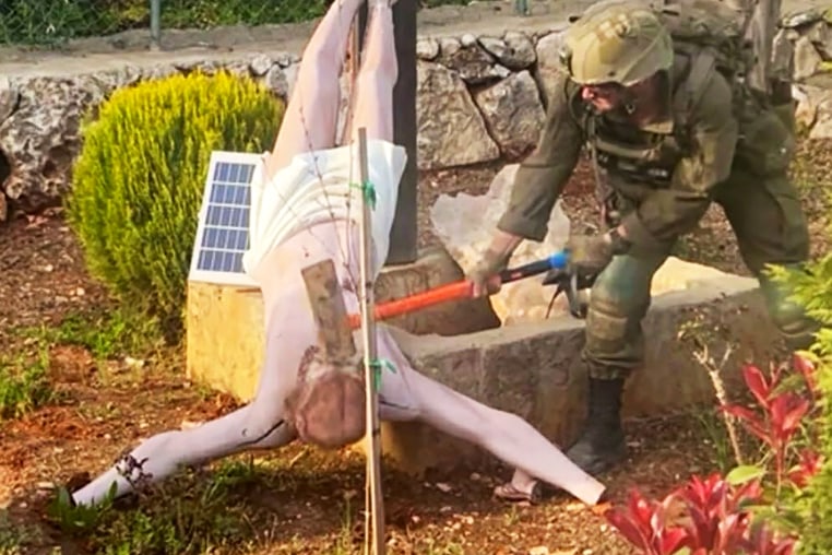 An IDF soldier damaging a Jesus statue in southern Lebanon.