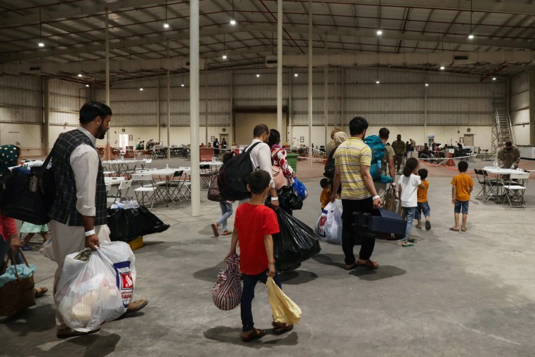 In this handout image Afghan Special Immigrants walk through the in-processing building