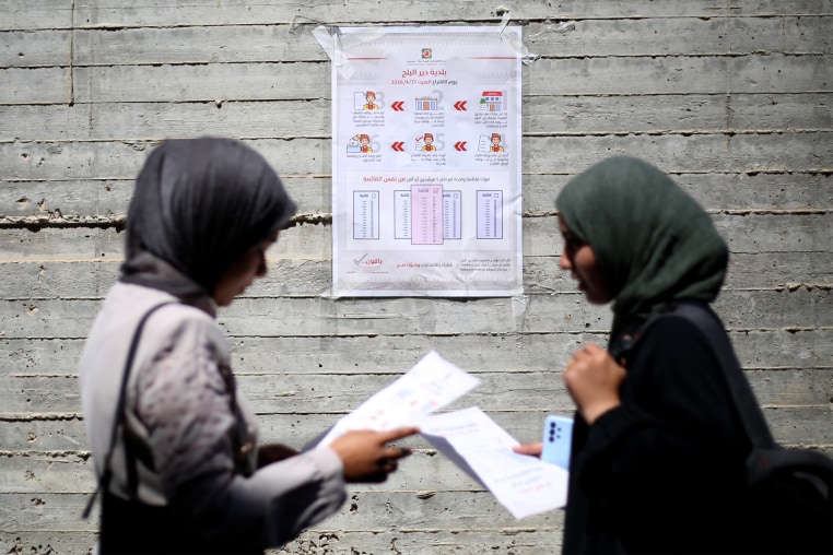 Women read instructions to voters ahead of the upcoming municipal elections in Deir el-Balah in the central Gaza Strip on April 21.