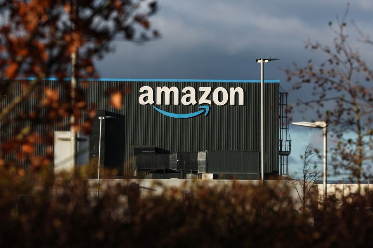 An Amazon warehouse as seen from outside through foliage