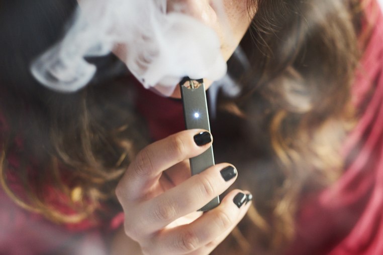 A person smokes an E-Cigarette. 