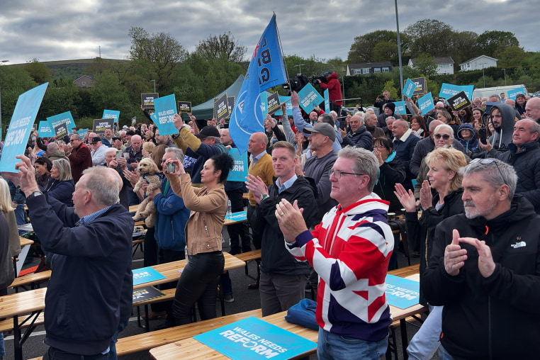 Crowds cheer Reform party leader Nigel Farage as he takes the stage at a rally in Merthyr Tidfil, Wales on Tuesday.