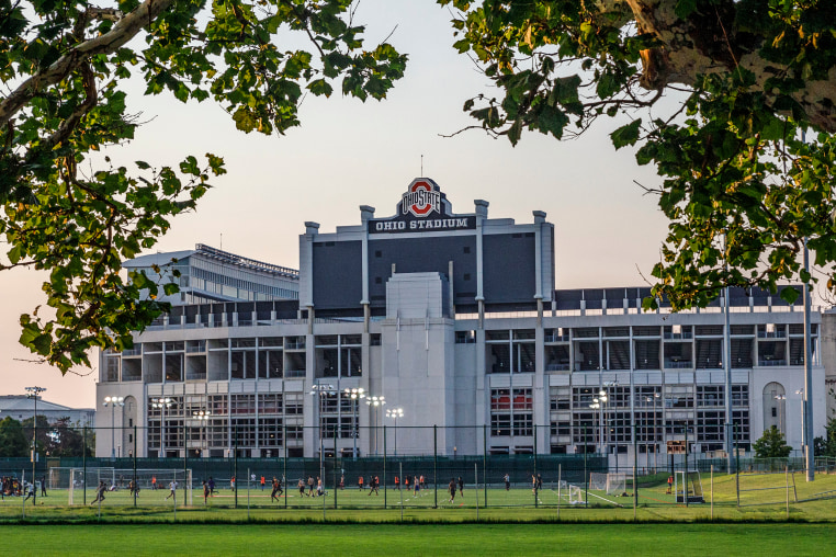 Students play soccer with the Ohio Stadium in the background