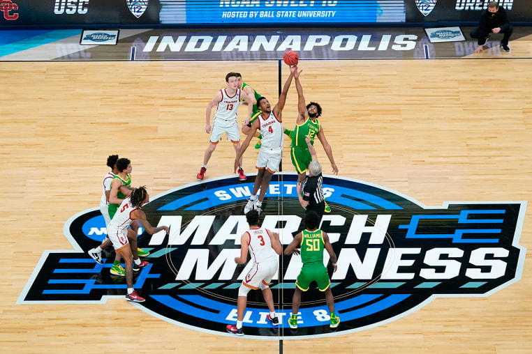 Southern California forward Evan Mobley fights for the opening tipoff with Oregon guard LJ Figueroa during a "March Madness" game in 2021.