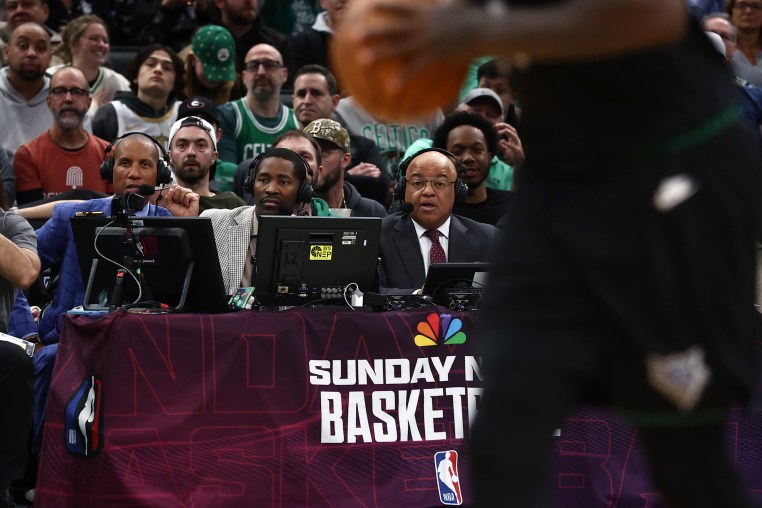 Three NBC sportscasters seated courtside during a basketball game.