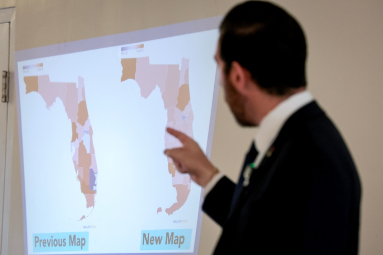 Oliver Larkin, Democratic candidate for Congress in Florida’s 23rd district, speaks during an emergency town hall that he held to address Florida Republicans’ newly approved congressional redistricting map (seen on wall).