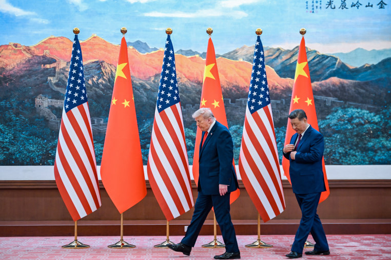 China's President Xi Jinping (R) receives US President Donald Trump