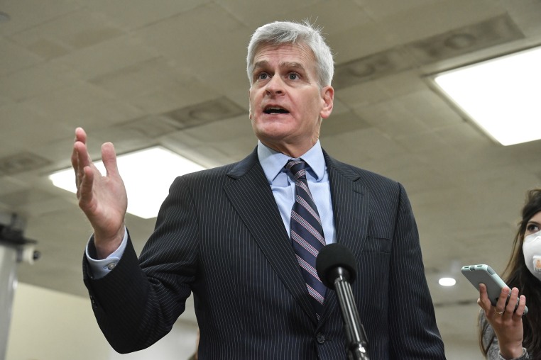 Bill Cassidy gestures with one hand while speaking into a microphone inside a U.S. Capitol building.