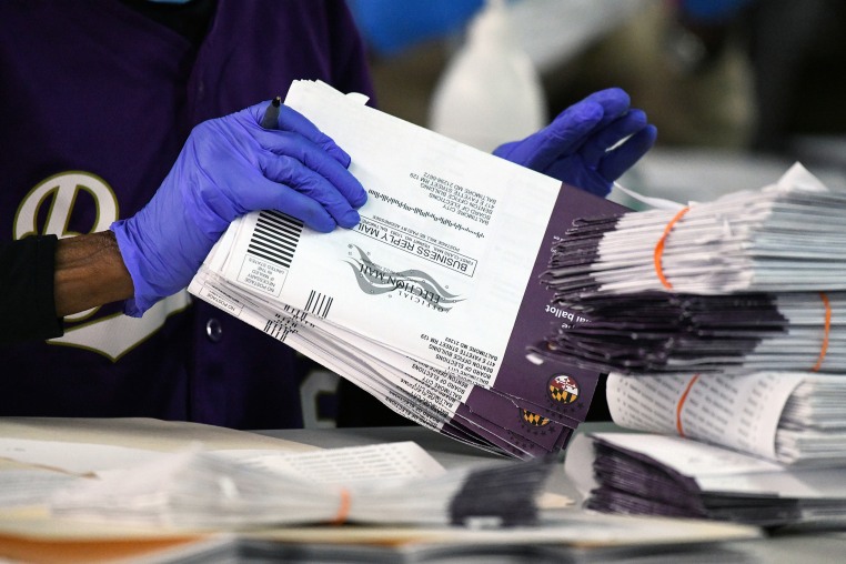 Canvassers open and review mail-in and absentee ballots for the 2024 General Election at the Baltimore City Board of Elections.