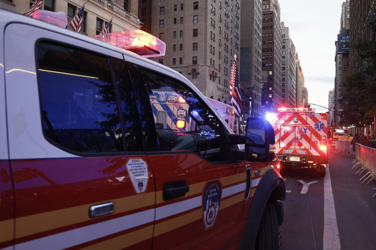Fire Department vehicles with emergency lights flashing in Manhattan at dusk.