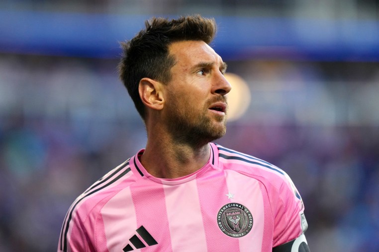 Lionel Messi wears a pink jersey on the soccer field