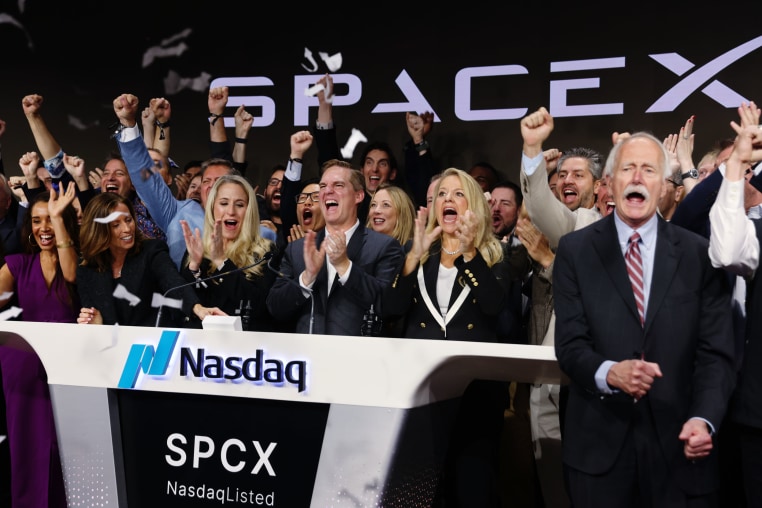 Bret Johnsen, chief financial officer of SpaceX, center, and Spacex President Gwynne Shotwell, center right, during the company's initial public offering at the Nasdaq MarketSite in New York on Friday, June 12, 2026.