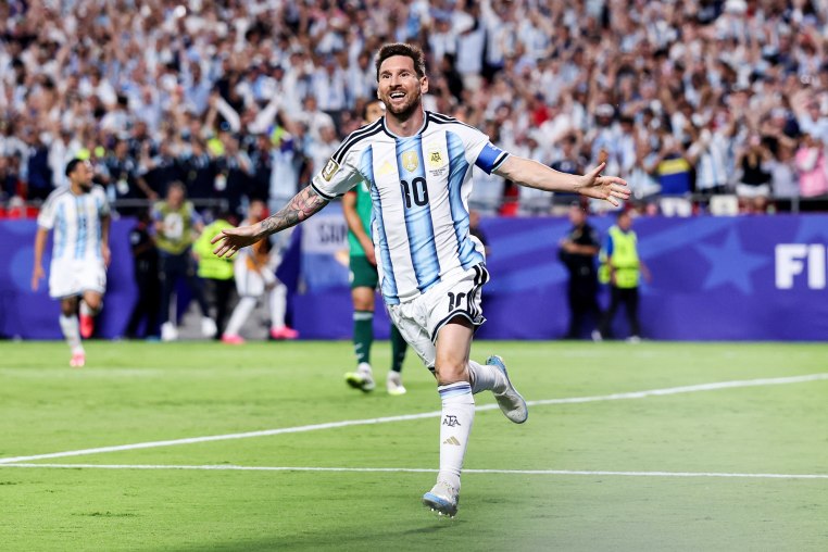 Lionel Messi runs on the soccer field in celebration