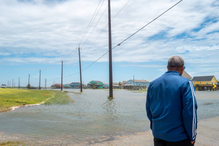 A person looks out towards a flooded neighborhood after Tropical Storm Arthur made landfall.