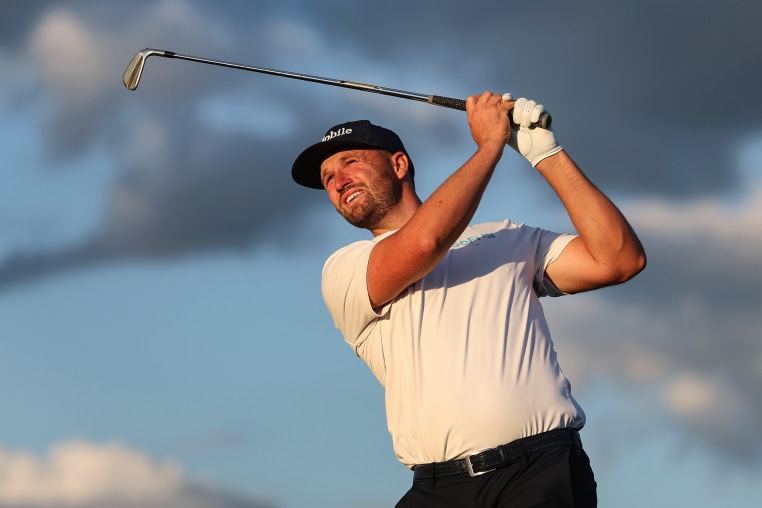 Wyndham Clark swings a golf club in the air outside