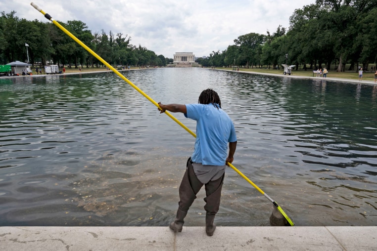 A worker cleans the waters of the Reflecting Pool in Washington on June 22, 2026. 
