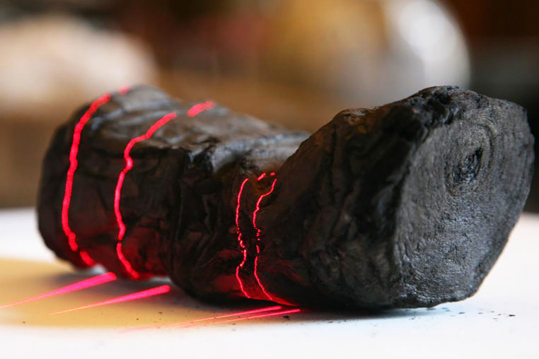 Herculaneum scroll with red laser lines being scanned at Institut de France by Brent Seales and his team.