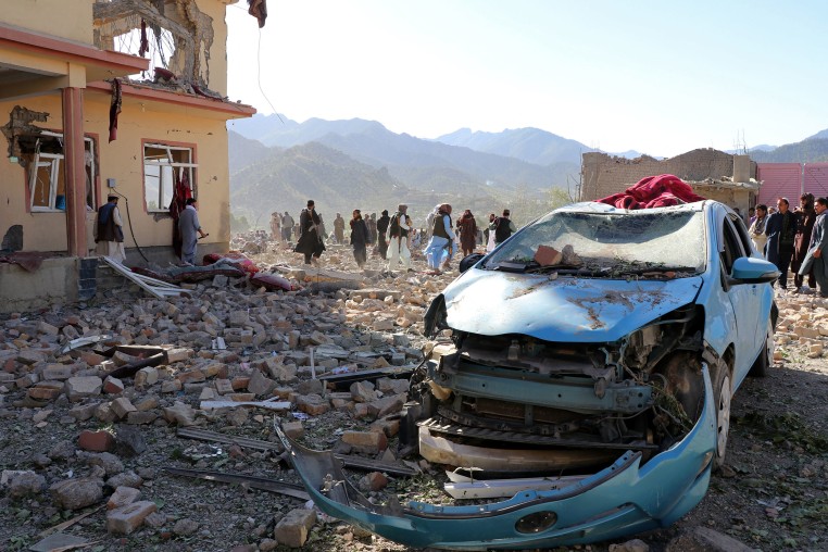 Image: Afghan residents look at the remains of a building damaged in a Pakistani airstrike 