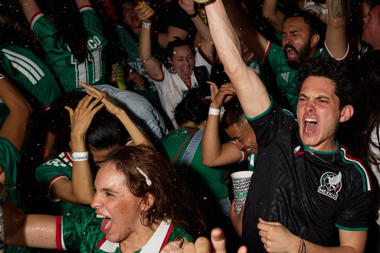 Image: Mexico football fans celebrate, spraying bottles of alcohol