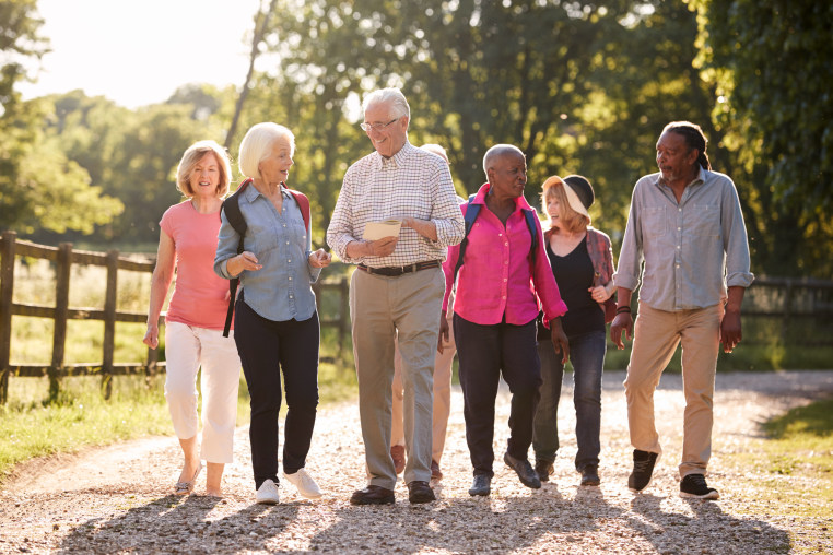 Group Of Senior Friends Hiking In Countryside