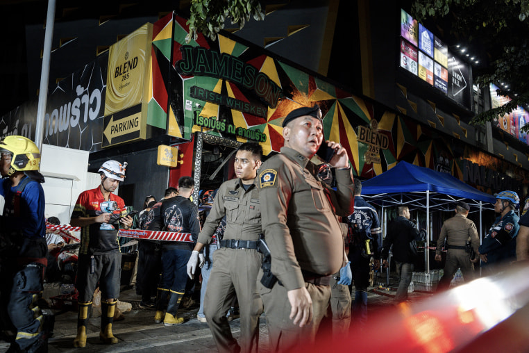 Police officers and emergency responders at the scene of a fire in Bangkok.