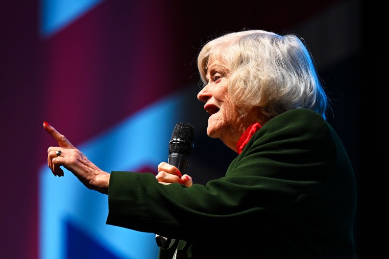 Ann Widdecombe, Immigration and Justice spokeswoman for Reform UK, with a mic and a UK flag in the background, at Westpoint Arena during the South West conference.