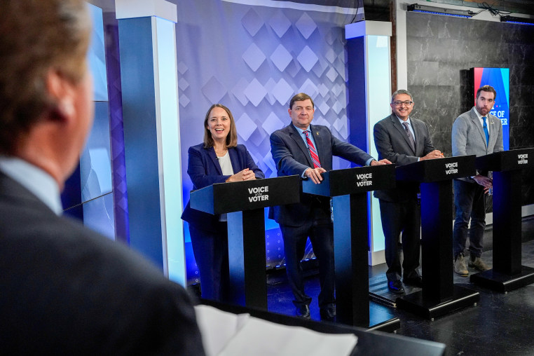 From podium left, U.S. Senate candidates Shenna Bellows, Troy Jackson, Dr. Nirav Shah, and Jordan Wood talk with moderator Phil Hirschkorn.