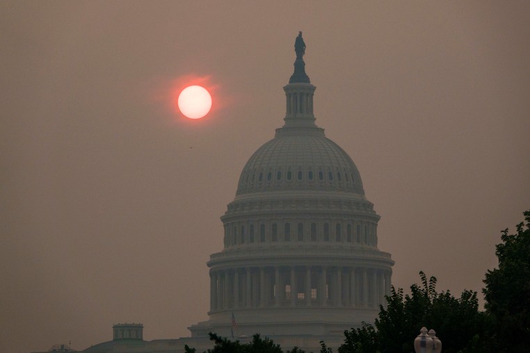 The sun rises behind the U.S. Capitol.