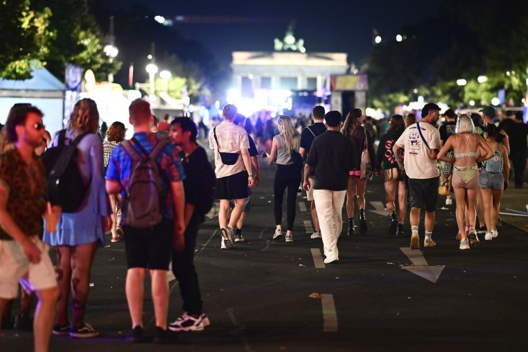 A crowd of young adults in the street at night.