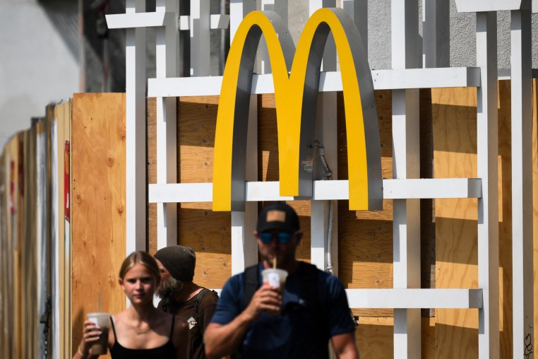 The McDonalds logo is displayed as people walk in the street.