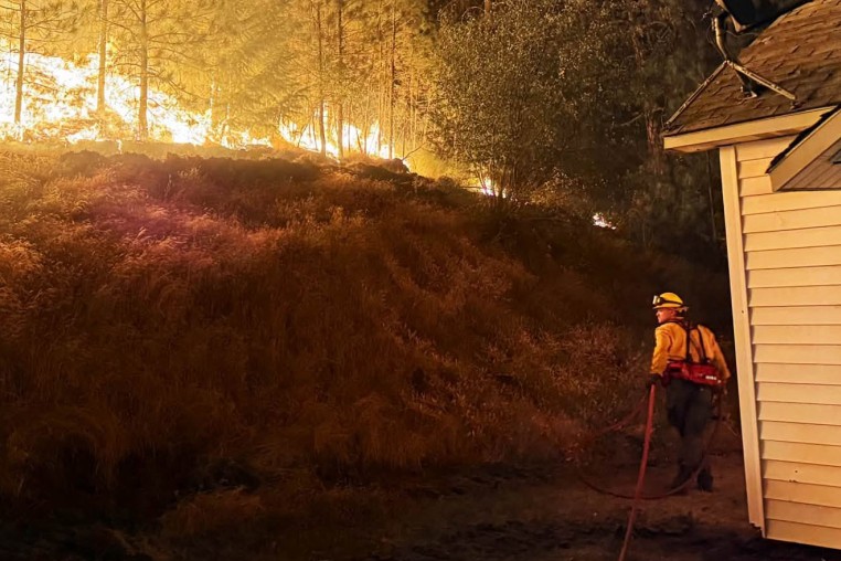 A firefighter battles the Fairview Fire in Spokane County, Wash.