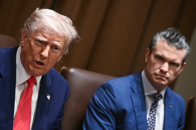 Donald Trump speaks while sitting next to Pete Hegseth at the table.