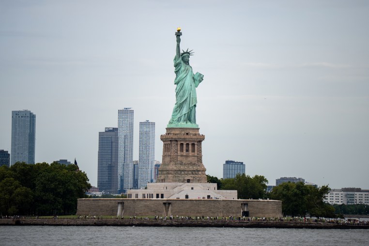 The Statue of Liberty seen from across the water on a cloudy day