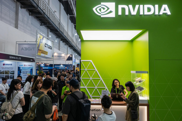 Nvidia Corp. branding logo appears at a fair booth while people walk around the expo fair.