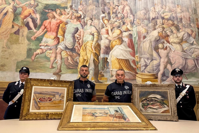 Carabinieri hold artwork.