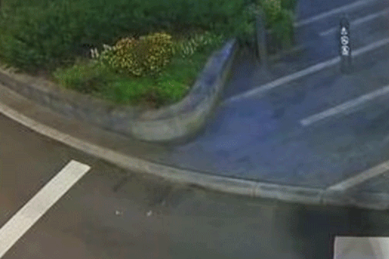 A GIF of a jogger being chased at night on the sidewalk by a person in a black hoodie wearing a Chucky mask and backpack