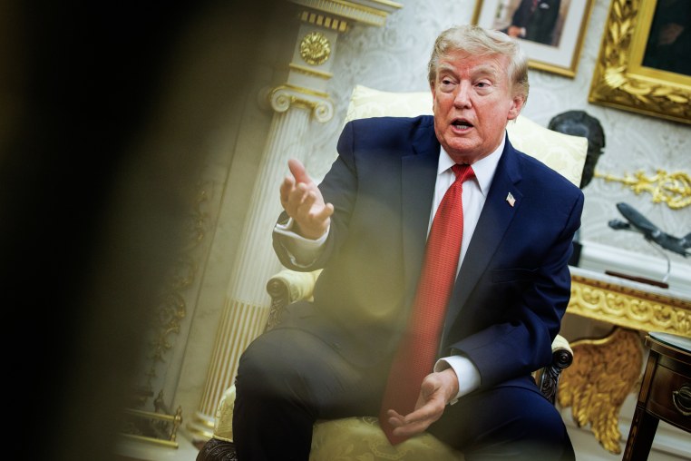 Donald Trump speaks while seated in a chair in the Oval Office