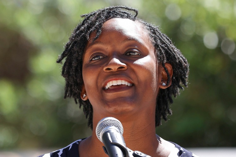 Angie Nixon speaks into a microphone outside