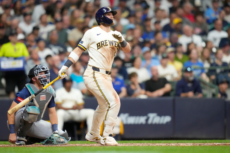 Jake Bauers #9 of the Milwaukee Brewers hits a two run homer in the sixth inning as Cal Raleigh #29 of the Seattle Mariners looks on at American Family Field on August 18, 2026 in Milwaukee, Wisconsin.