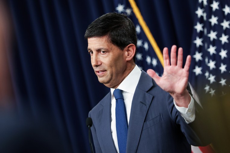 Kevin Warsh speaks while holding a hand up