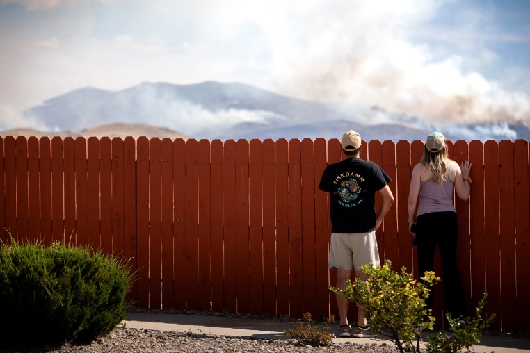 Residents look at the Hawk Fire burning on Aug. 23, 2026 in Reno, Nev.