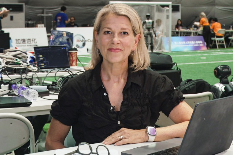Janis Mackey Frayer smiles while seated at a table in front of her laptop