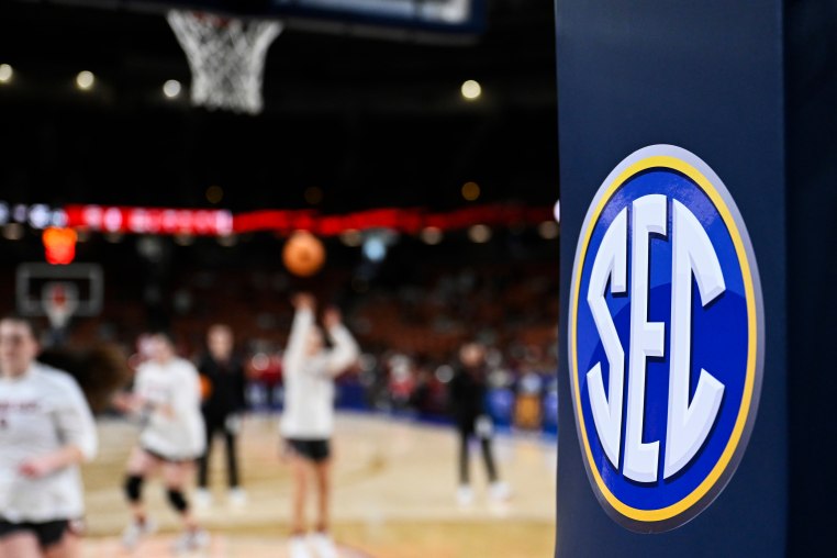 The SEC logo is seen while people play on the court.