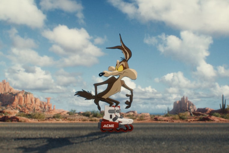 An animated coyote standing on the middle of the street while wearing rolling skates.