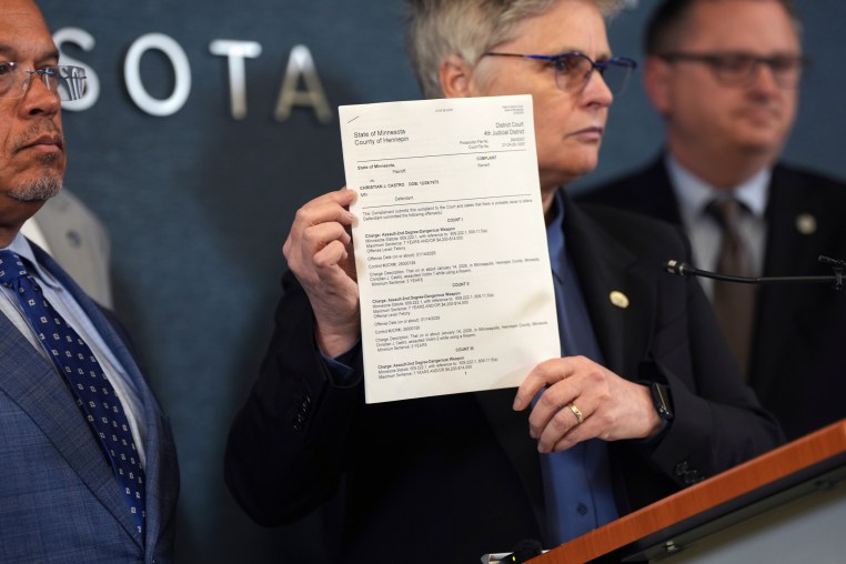 A woman holds a document during a press conference.