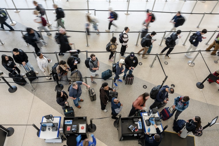 A blur of travelers in an airport seen from above.